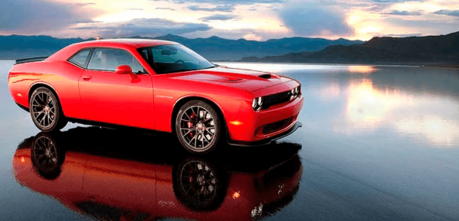 red dodge hellcat on water with sunset background