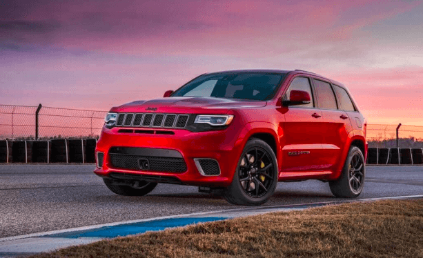 red jeep suv on road with pink sunset